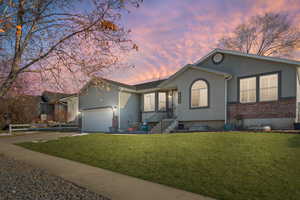 Ranch-style house with a garage and a lawn