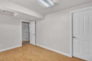 Spare room featuring a textured ceiling and light wood-type flooring