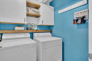 Washroom with cabinets and washing machine and dryer