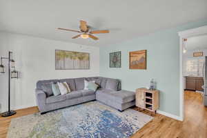 Living room featuring wood-type flooring and ceiling fan