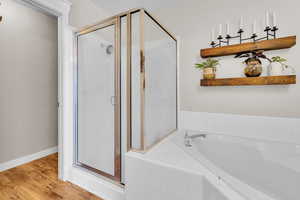 Bathroom featuring separate shower and tub and hardwood / wood-style floors