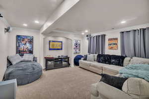 Carpeted living room with indoor bar and ornamental molding