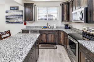 Kitchen featuring quartz countertops, stainless steel appliances, beautiful upgraded cabinets, with a center island