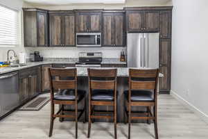 Kitchen featuring quartz countertops, stainless steel appliances, beautiful upgraded cabinets, with a center island