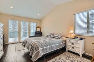 Bedroom with hardwood / wood-style flooring and vaulted ceiling