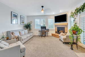 Carpeted living room with a brick fireplace