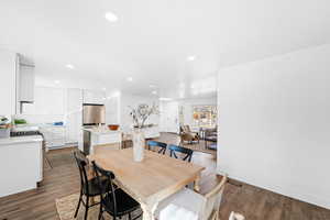 Dining space with sink and dark wood-type flooring