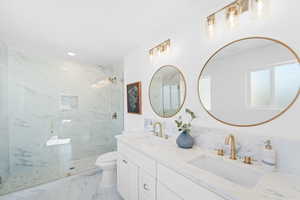 Bathroom featuring vanity, toilet, and a shower with shower door