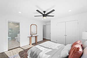 Bedroom featuring ceiling fan, wood-type flooring, a closet, and ensuite bath