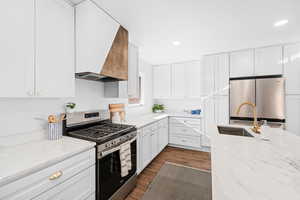 Kitchen featuring stainless steel appliances, white cabinetry, and dark wood-type flooring