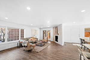 Living room with a large fireplace and dark hardwood / wood-style flooring