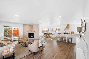 Living room with dark wood-type flooring, a healthy amount of sunlight, and a fireplace