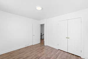 Unfurnished bedroom featuring hardwood / wood-style floors and a closet