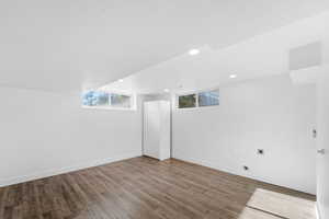 Basement with plenty of natural light and wood-type flooring