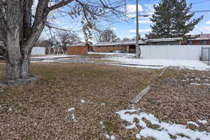 Yard layered in snow with a storage unit