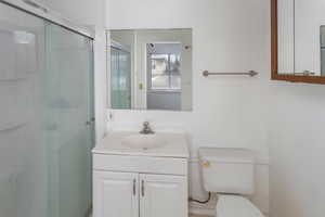 Bathroom with walk in shower, vanity, and toilet