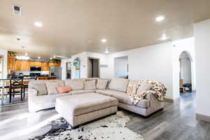 Living room with washer / clothes dryer, wood-type flooring, and a notable chandelier