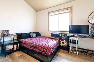 Bedroom with vaulted ceiling and hardwood / wood-style floors