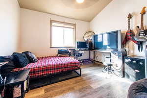 Bedroom featuring wood-type flooring and vaulted ceiling