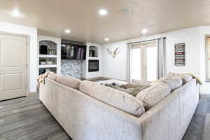 Living room with french doors, dark hardwood / wood-style flooring, and built in shelves