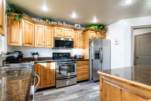 Kitchen featuring appliances with stainless steel finishes, light hardwood / wood-style floors, and sink