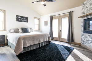 Bedroom featuring french doors, ceiling fan, lofted ceiling, and hardwood / wood-style floors