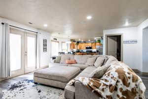 Living room with french doors and light hardwood / wood-style flooring