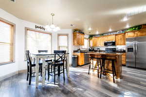 Dining space featuring wood-type flooring, sink, and an inviting chandelier