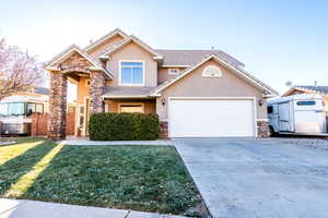 View of front of home with a garage and a front lawn