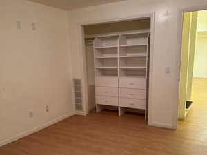 Unfurnished bedroom with light hardwood / wood-style flooring, a closet, and a textured ceiling