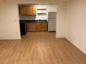 Kitchen featuring white refrigerator, dishwasher, and light hardwood / wood-style floors