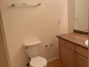 Bathroom featuring vanity, hardwood / wood-style floors, and toilet