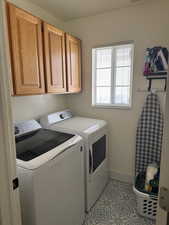 Laundry area featuring cabinets, washer and dryer, and light tile patterned flooring