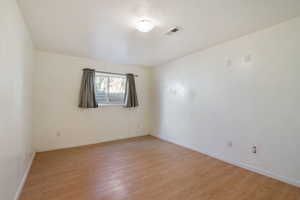 Spare room with visible vents, baseboards, and light wood-style floors