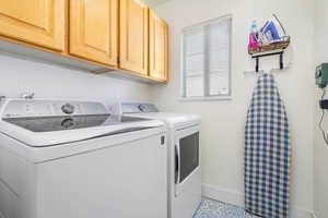 Laundry room featuring cabinet space, baseboards, and separate washer and dryer