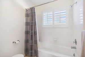 Full bath featuring toilet and shower / tub combo
