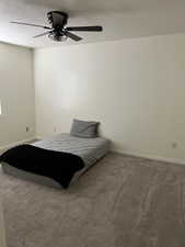 Bedroom featuring a ceiling fan, carpet flooring, a textured ceiling, and baseboards