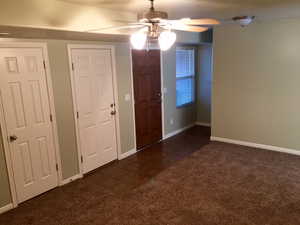 Carpeted foyer entrance featuring ceiling fan