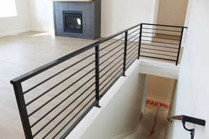 Staircase featuring hardwood / wood-style floors and a brick fireplace