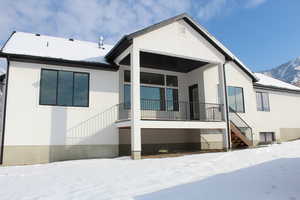 Snow covered rear of property featuring a mountain view