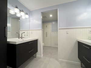 Bathroom featuring crown molding, vanity, toilet, and tile patterned flooring