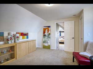 Interior space with light colored carpet and vaulted ceiling