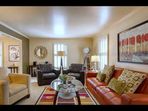 Carpeted living room with ornamental molding