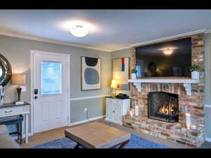 Living room featuring a fireplace, crown molding, and carpet floors