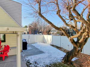 Snowy yard featuring a patio area