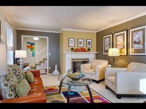 Carpeted living room with a brick fireplace and ornamental molding