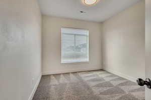 Carpeted spare room with baseboards