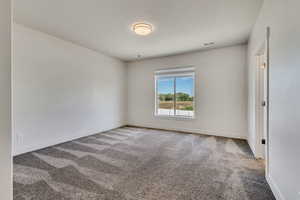 Spare room featuring carpet floors and baseboards