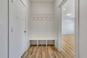 Mudroom featuring light wood finished floors and baseboards