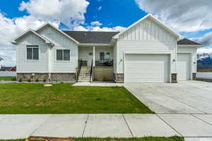 View of front of house featuring a garage, a front yard, and a porch